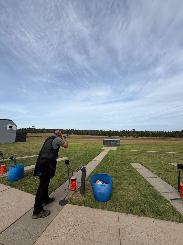 Member shooting clay targets at an outdoor trap range
